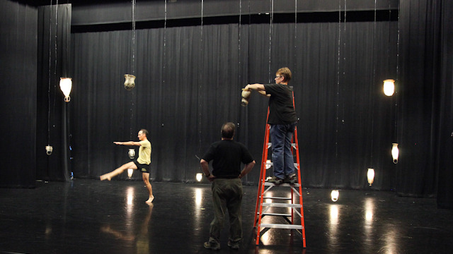 Eckwall works to hang the 38 fish skin lanterns in the Nancy Smith Fichter Dance Theatre.